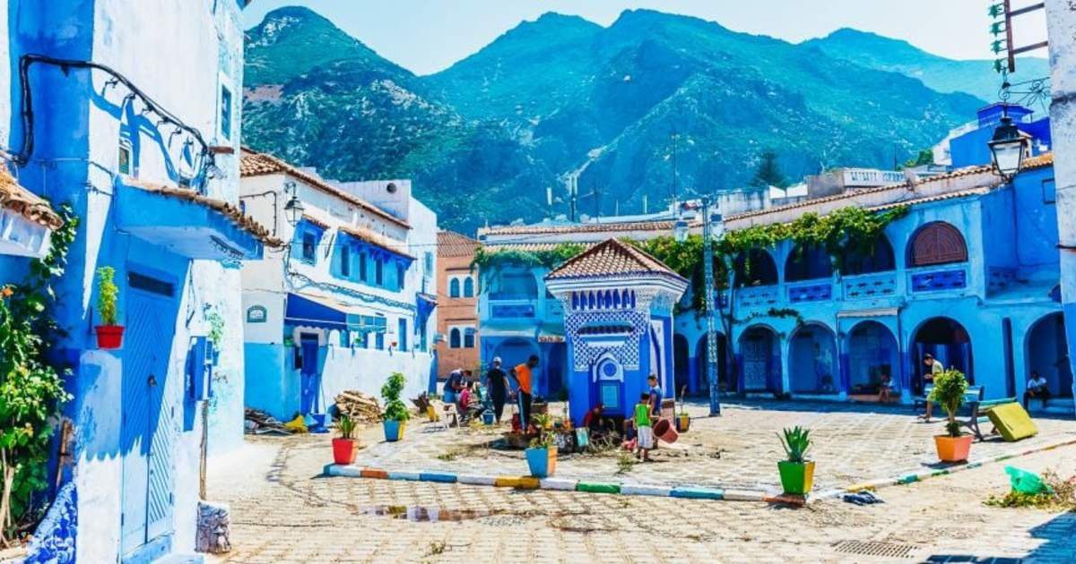 Chefchaouen iconic blue-painted medina square with colourful
flower pots and Rif Mountains backdrop --- Morocco Live Trips 8-day tour
via Chefchaouen and Fes