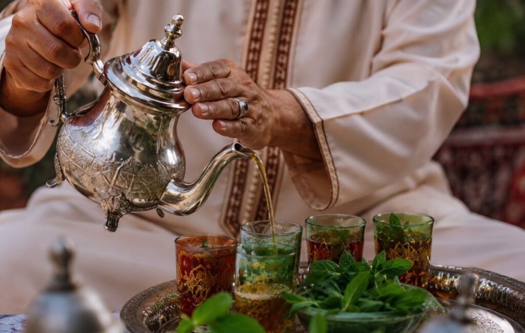 A close-up of hands pouring traditional Moroccan tea